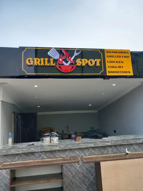 Grill Spot fascia sign with menu panel above a hotel grill counter