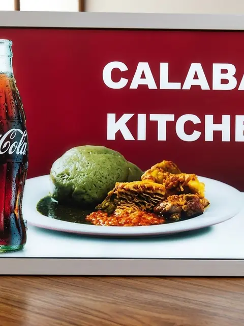 Illuminated Calabar Kitchen menu lightbox with Coca-Cola branding