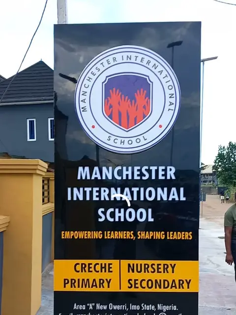 Black totem sign for Manchester International School in New Owerri