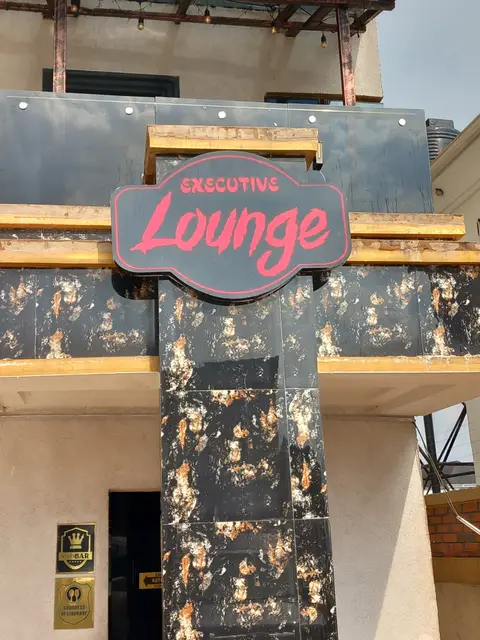 Shaped and routed Executive Lounge sign mounted on a marble column